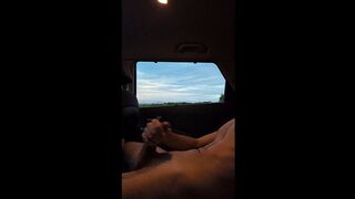 Jerking off in the car with sunset as trucks go by