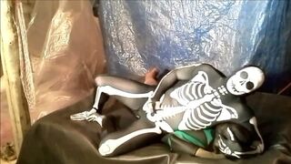 fantasy scene where spandex skeleton wrestles and humps frogman