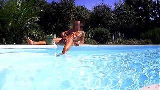 muscular guy jerks off by the pool wide shot