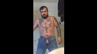 Tattooed man jerks fat cock through the fly